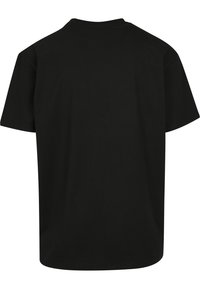 Black cotton t-shirt with short sleeves, crew neck, and a relaxed fit. Smooth texture and simple design without patterns or accents.