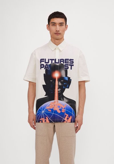Lühikeste varrukatega kreemivärvi särk, millel on julge graafiline kujutis näost ja maakelast tumedates ja neoonvärvides, kus peal on tekst "FUTURES PAST".