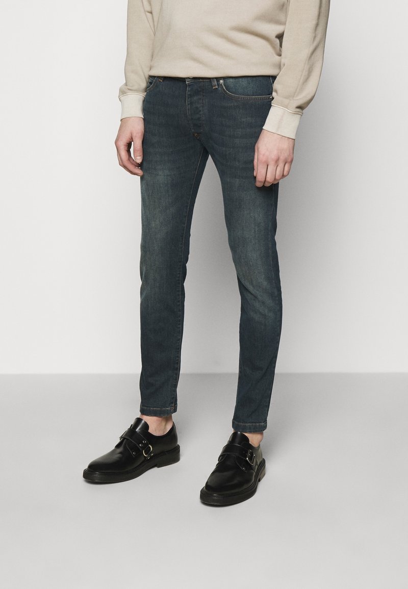 Mörkblå skinny jeans i denim, med en blekt tvätt, femfickdesign och slim fit, parat med svarta skor.