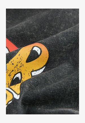 Čierny látkový materiál s farebnou grafickou potlačou, obsahujúcou žlté a biele akcenty, s textúrovaným povrchom a zvlnenými záhybmi.