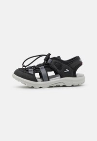 Svarte og grå sandaler med et luftig design, elastiske lisser og en teksturert gummisåle for godt grep. Detaljer inkluderer en logo på hælen.