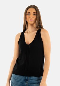 Débardeur noir sans manches en maille avec un décolleté en V, présentant un ourlet côtelé et des détails de texture verticale. Convient pour un usage décontracté.