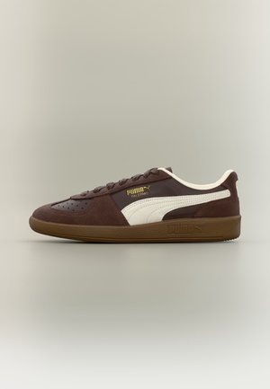Baskets Puma Palermo marron avec une bande blanche, semelle en gomme et logo Puma doré sur le côté, vues de l'extérieur.