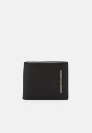 Black leather wallet with a textured surface, featuring a silver-tone Calvin Klein logo accent. Compact bi-fold design.
