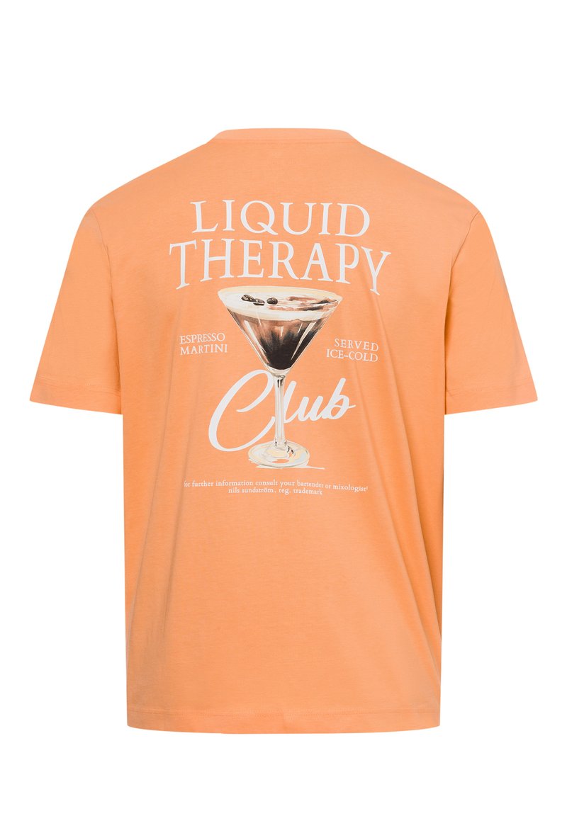 Peach-colored t-shirt with short sleeves. Features a graphic print of a martini glass and text stating "Liquid Therapy" in white.