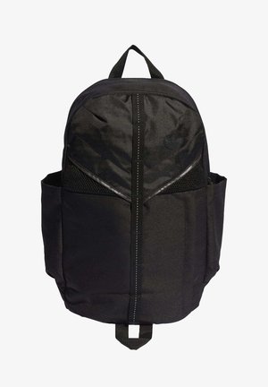 Sac à dos en tissu noir avec une bande verticale sur le devant, des poches latérales en mesh, une poignée supérieure et un petit logo embossé dans la partie supérieure droite.