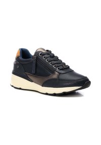Zapatilla de cuero negra con acentos grises, panel lateral texturizado, diseño de cordones, detalle de cremallera lateral y suela de goma blanca.