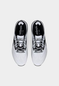 Ζευγάρι λευκά και μαύρα παπούτσια τρεξίματος Reebok με κορδόνια με σχέδιο, από πάνω σε λευκό φόντο.