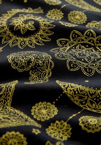 Tissu noir orné de motifs complexes de mandalas dorés et de fleurs, créant un design décoratif et symétrique sur toute la surface.