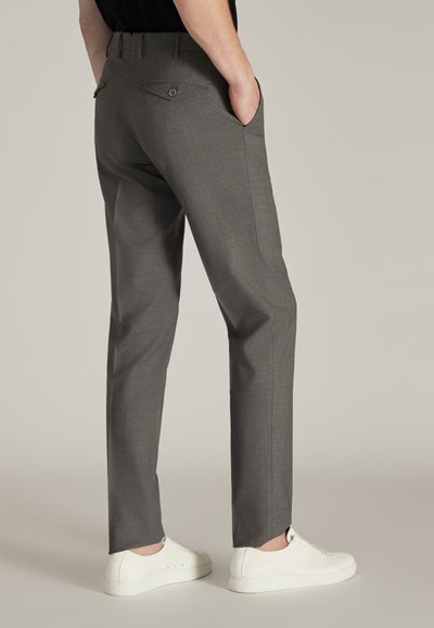 Grijze op maat gemaakte broek met een gladde textuur, voorzien van zakken en knoopsluitingen op de achterflap, gecombineerd met witte sneakers.