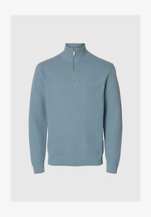 Lichtblauwe gebreide trui met lange mouwen, ribbelmanchetten en -zoom, en een korte rits aan de hoge kraag.