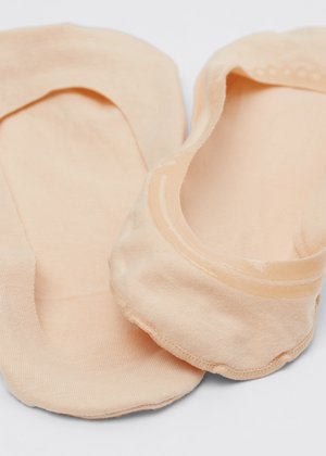Par de calcetines plantilla invisibles beige hechos de tela fina y suave, mostrados sobre una superficie blanca.
