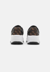 Sneakers neri con motivo del logo marrone, suole in gomma e intersuola bianca. La vista posteriore mette in mostra il materiale testurizzato e il collo imbottito.