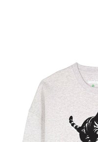 Chemise gris clair avec un graphique de chat rayé noir et blanc sur le devant, encolure ronde et manches courtes.