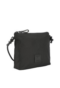 Borsa in nylon nera con superficie texture, dotata di zip superiore, una tracolla nera e un piccolo logo sul davanti.