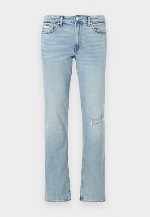 Világoskék egyenes szárú farmernadrág szakadt résszel a jobb combnál, első zsebekkel és gombos derékrésszel.