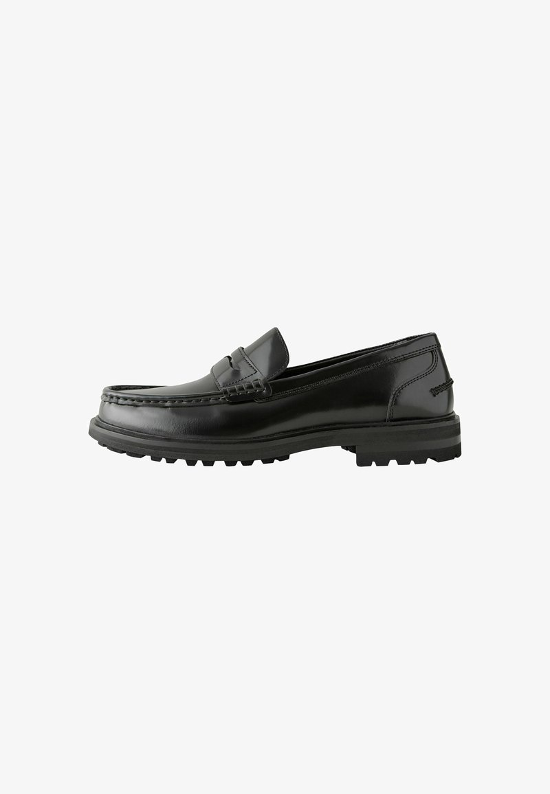 Mocassins en cuir noir avec une finition lisse, présentant un design cousu, un petit talon empilé et une semelle en caoutchouc durable avec une meilleure adhérence.