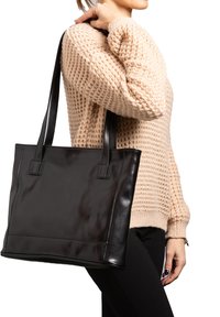 Zwarte leren tote bag met een gladde afwerking, rechthoekige vorm en dubbele korte handvaten. Inclusief nette stiksel en minimalistisch ontwerp.