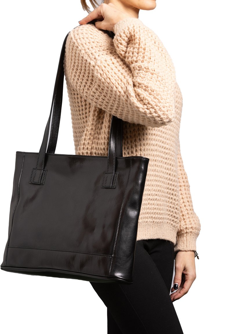 Zwarte leren tote bag met een gladde afwerking, rechthoekige vorm en dubbele korte handvaten. Inclusief nette stiksel en minimalistisch ontwerp.