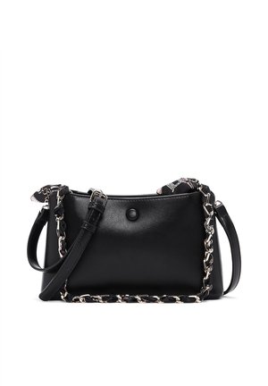 Bolso de mano de cuero negro con correa de hombro ajustable, cadena y detalle de tela tejido a través de la cadena, y cierre con botón en la parte delantera.