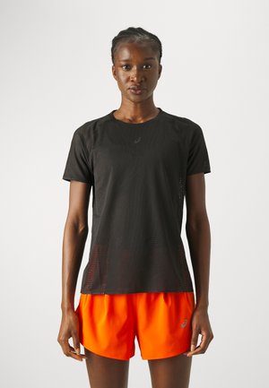 Black athletic shirt featuring a textured, perforated design. Paired with bright orange shorts, both designed for comfort and mobility.