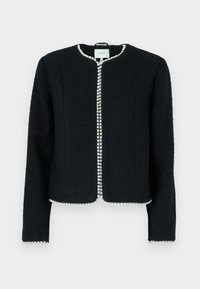 Veste noire texturée avec un col rond, coupe ajustée, et accent en perles le long de la fermeture avant, présentant des manches longues et sans fermetures visibles.