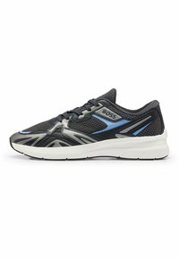 Baskets de sport noires et grises avec tige en mesh, accents bleus, semelle blanche rembourrée et lignes de design uniques pour la ventilation et le style.