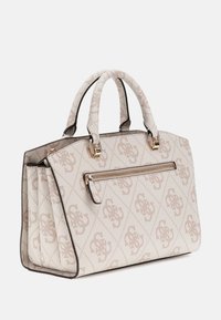 Sac à main beige à motif avec des poignées doubles, des éléments en métal doré, une poche avant zippée et un design structuré mettant en valeur des détails de logo.