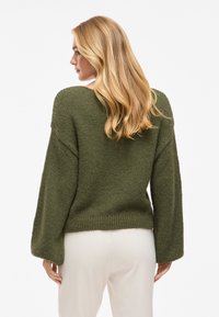 Olivenfarbener, gestrickter Pullover mit lockerer Passform, weitem Ärmel und geripptem Saum. Strukturiertes Material und V-Ausschnitt-Design.