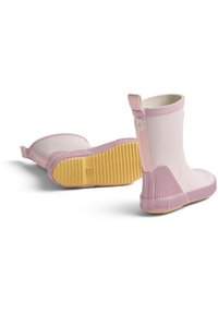 Een paar lichtroze rubberen regenlaarzen met gele, getextureerde zolen, waarvan de ene laars rechtop staat en de andere op zijn zij ligt tegen een witte achtergrond.