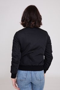 Sort bomberjakke med en glat tekstur, ribbede manchetter og kant, polstret design og sidelomme, båret over blå højtaljede jeans.
