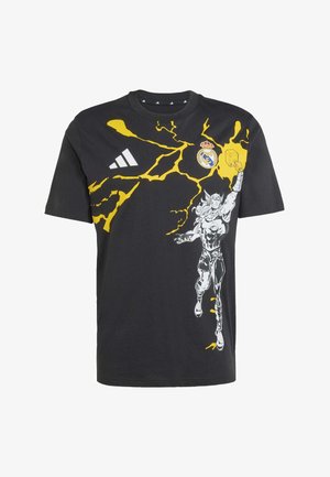 Black cotton t-shirt featuring a yellow lightning graphic and a printed figure on the front. Includes the Adidas logo and Real Madrid emblem.