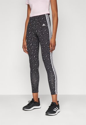 Zwarte leggings met een luipaardprintpatroon, voorzien van witte zijstripes en een Adidas-logo. Gemaakt van rekbare stof voor comfort.