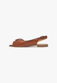 Sandalia slingback de cuero marrón con punta abierta, suela plana y un adorno decorativo de hebilla en la correa. Textura suave y diseño aerodinámico.