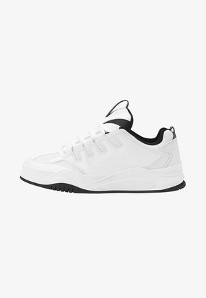 Baskets blanches de sport présentant un dessus en synthétique lisse, des accents noirs, un col rembourré, une semelle texturée et un design de lacets contrasté.