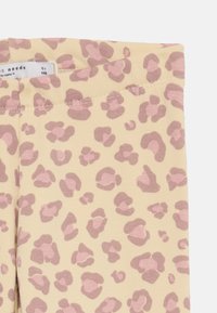 Leggings beige pour enfants avec un motif léopard rose et marron, taille 5 ans, avec une taille élastique.