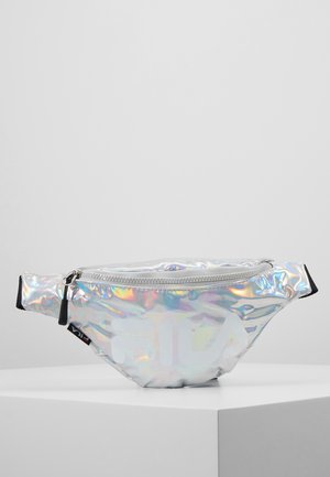 Holograficzna srebrna nerka Fila z zamkiem błyskawicznym i czarnym regulowanym paskiem, prezentowana na białej narożnej powierzchni.