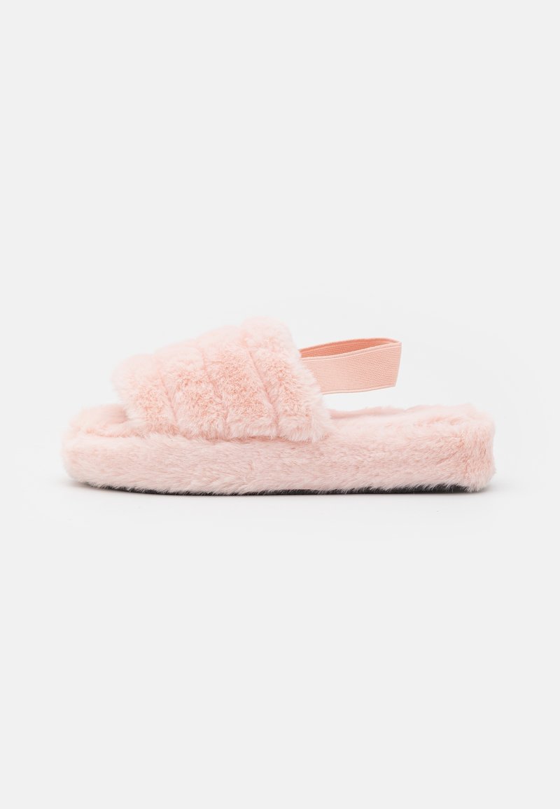 Chaussons roses duveteux avec une semelle épaisse, une bride sur le cou-de-pied et une tige texturée. Le matériau doux et moelleux offre un aspect confortable.