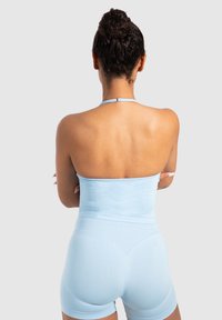 Body in tessuto elastico azzurro chiaro con un design aderente e una texture liscia. Presenta un collo alla halter e pantaloni corti, senza cuciture.