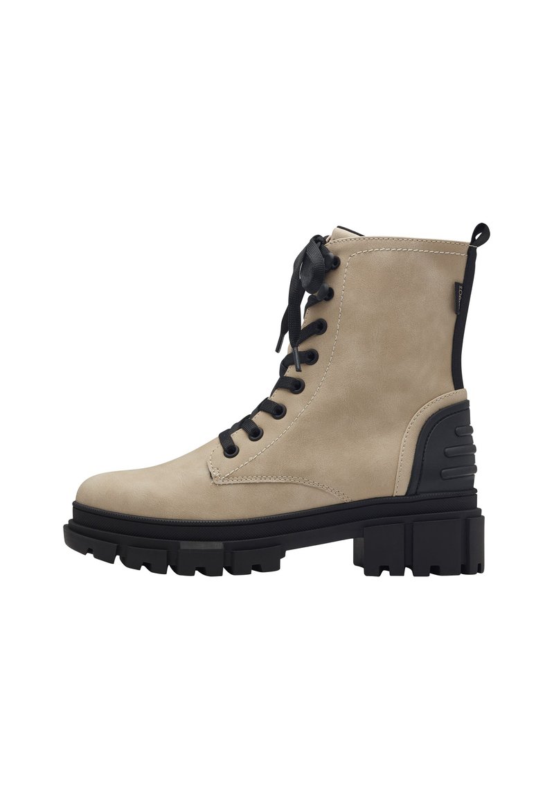 Bottine beige en suede avec semelle en caoutchouc noire, avant à lacets, col rembourré et accents de talon proéminents. Présente des coutures contrastantes.