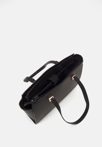 Sort læder tote taske med en struktureret form, lynlåse og hardware i guldfarve. Har to håndtag og en indvendig lomme.