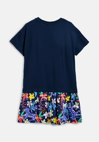Top cu manșon scurt, de culoare bleumarin, asociat cu o fustă plisată cu un imprimeu floral și animalier colorat. Material din bumbac, design casual și decolteu rotund.