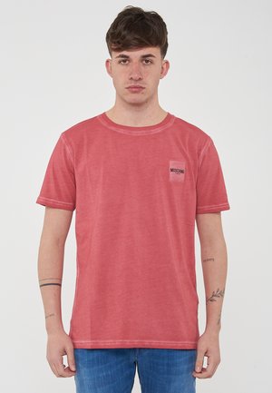T-shirt rossa in cotone con collo rotondo, maniche corte e un piccolo dettaglio sulla tasca con logo Moschino. Tessuto morbido con una vestibilità comoda.