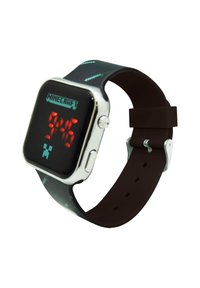 Digital watch with a square black face, red LED display, and green pixelated "Minecraft" logo. Silicone strap features a dark brown color.
