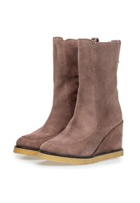 Botas de tobillo de cuña en ante color malva, con puntera redondeada y tacón elevado. Cremalleras laterales para facilitar su uso y suela de goma en contraste.