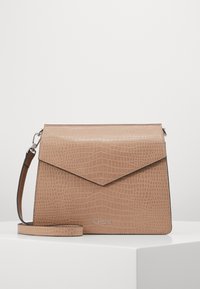 Borsa a tracolla in ecopelle beige con texture a crocodylo, chiusura a cappio triangolare e tracolla regolabile. Presenta un dettaglio logo in argento.