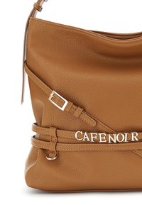 Torebka skórzana w kolorze tan o zaokrąglonym kształcie, z detalami w postaci paska i ozdobnym metalowym akcentem z napisem "CAFE NOIR." Teksturowana powierzchnia i zapięcie w formie klamry.