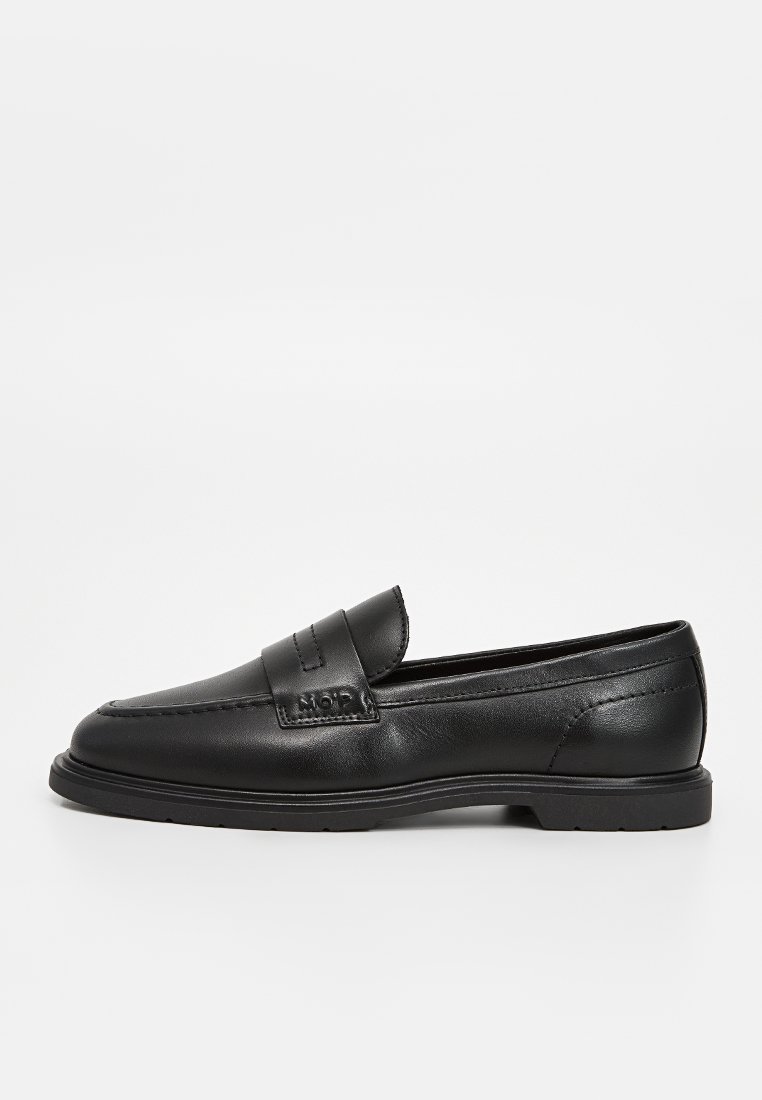 Schwarze Lederloafer mit rundem Zehenbereich, die mit einer genähten Akzentuierung über dem Spann und einer strukturierten, robusten Gummisohle ausgestattet sind.