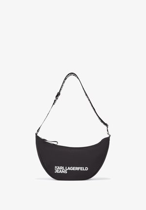 Crna platnena torba na ramenu u obliku polumjeseca, s bijelim logotipom "KARL LAGERFELD JEANS" i podesivim remenom. Zatvaranje na patentni zatvarač.