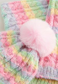 Bufanda de punto multicolor en tonos pastel de rosa, verde y amarillo, con un pom-pom rosado esponjoso como acento. Textura suave y diseño con patrón.